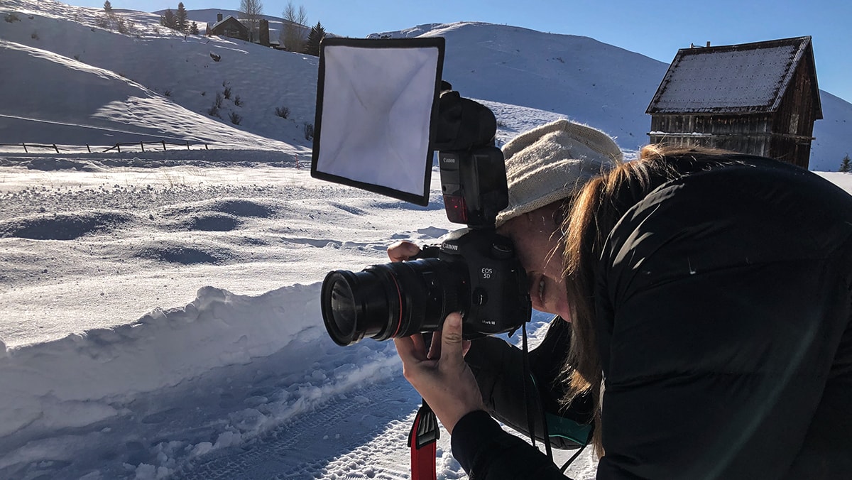 Photographer in the snow with additional lighting.