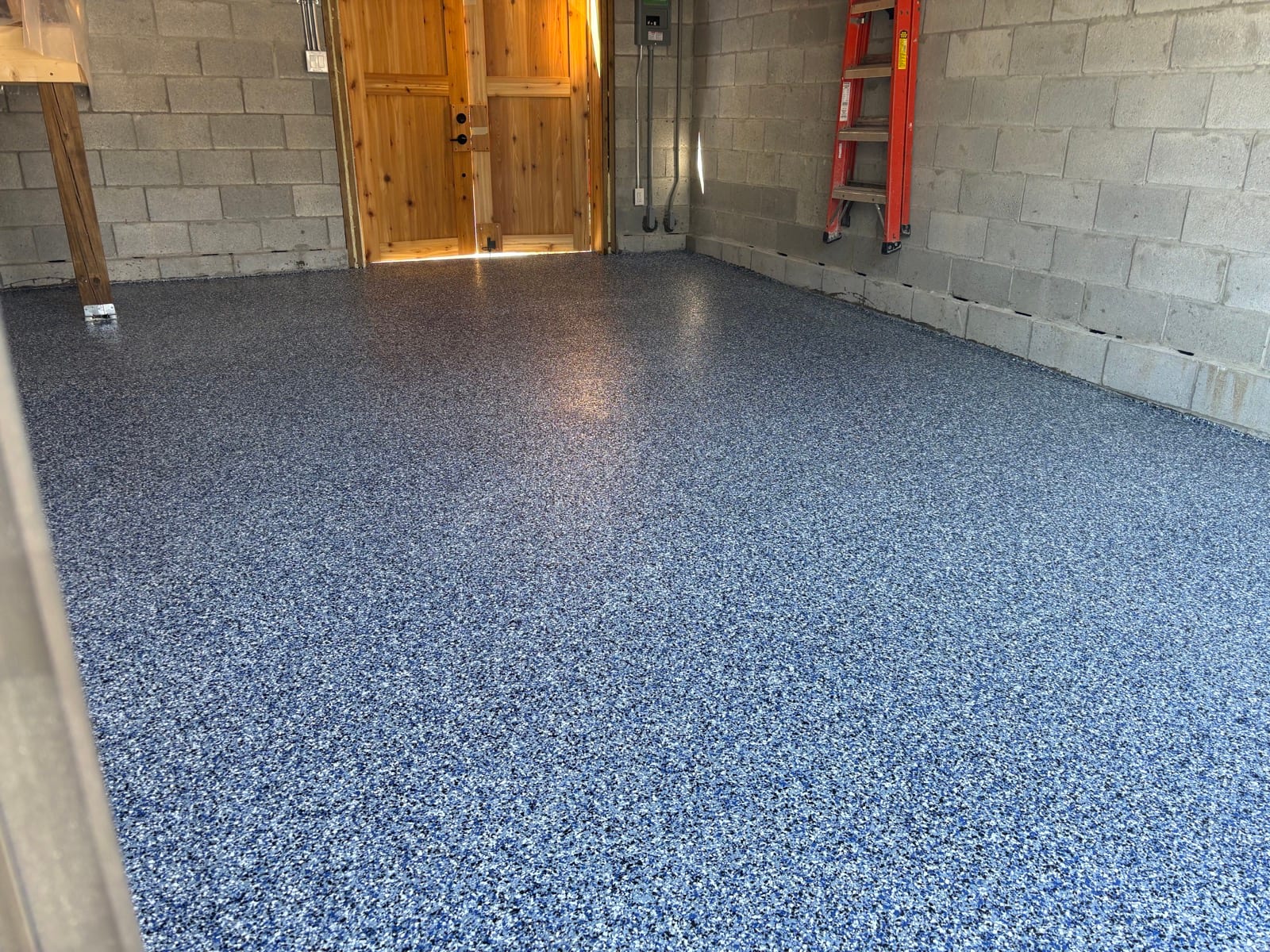 Glossy blue speckled epoxy floor near garage entrance