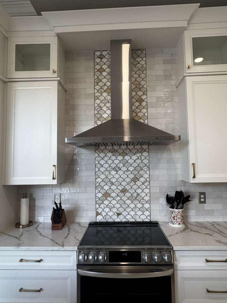 A sleek, renovated kitchen with white cabinets.