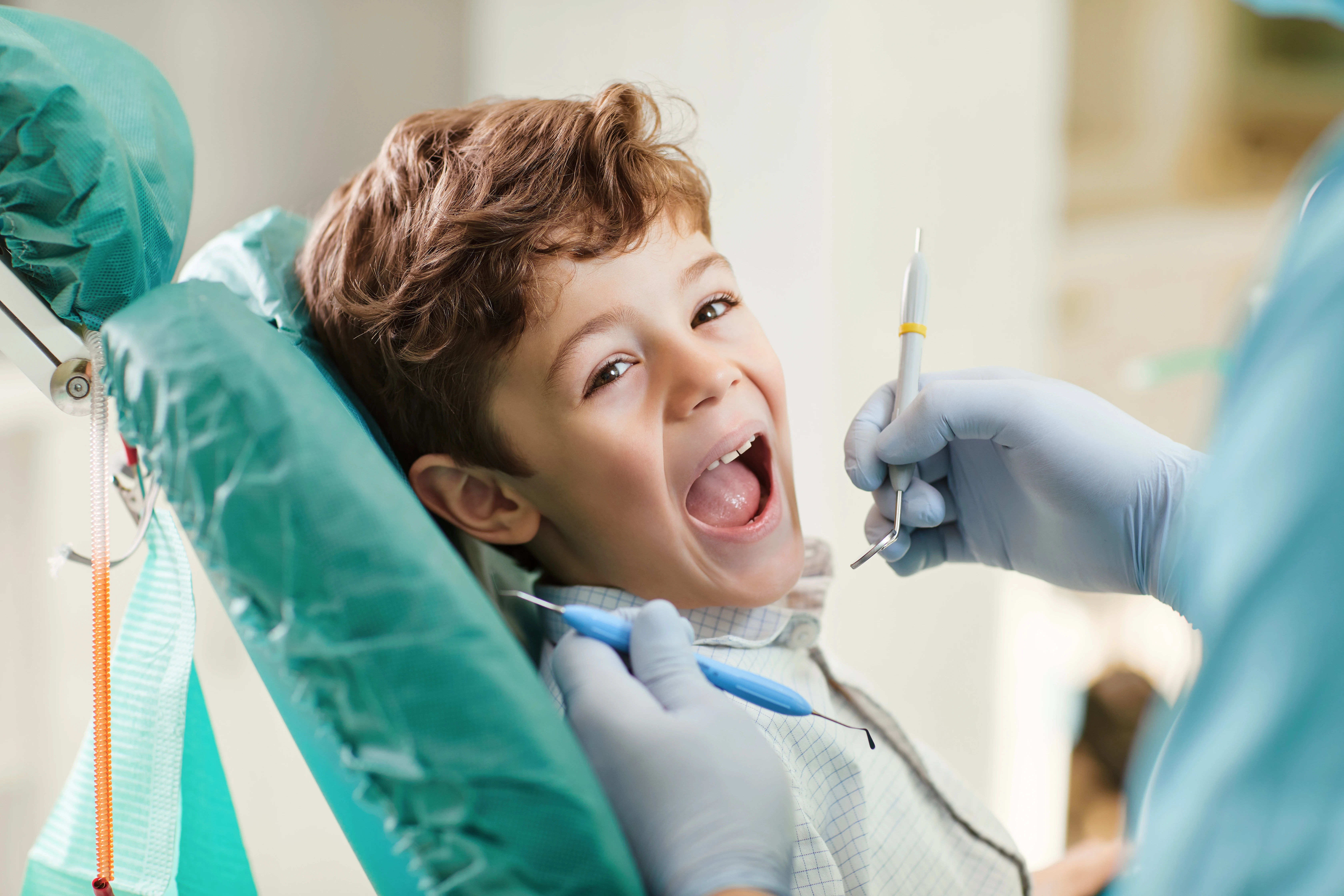 Dental hygienist gently cleaning a child's teeth at SeaGate Family Dental in Huntington Beach.