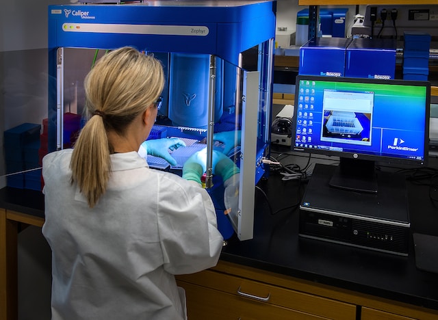 scientist interacting with her Caliper LifeSciences’ Zephyr Molecular Biology Workstation