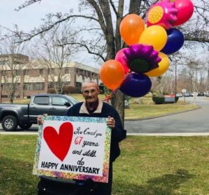 man-stands-outside-nursing-home-wedding-anniversary