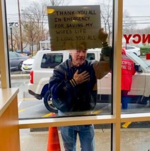 man-holds-sign-wife-nursing-home