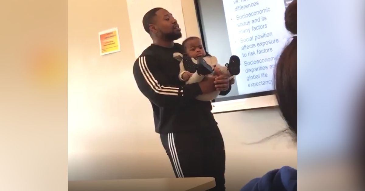professor holds students baby