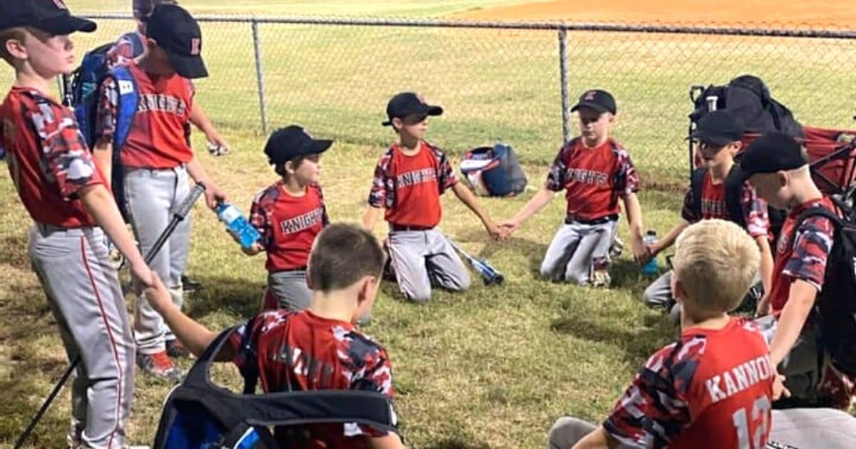 boys praying at ball field blake bastin