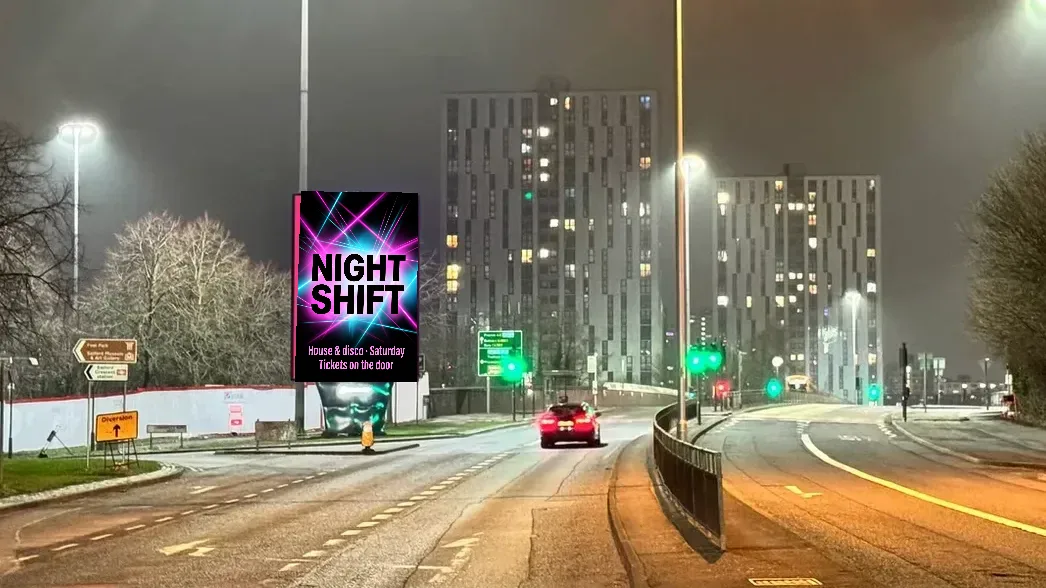 Example club night ad reading NIGHT SHIFT on a portrait roadside digital screen at night on The Crescent, Salford