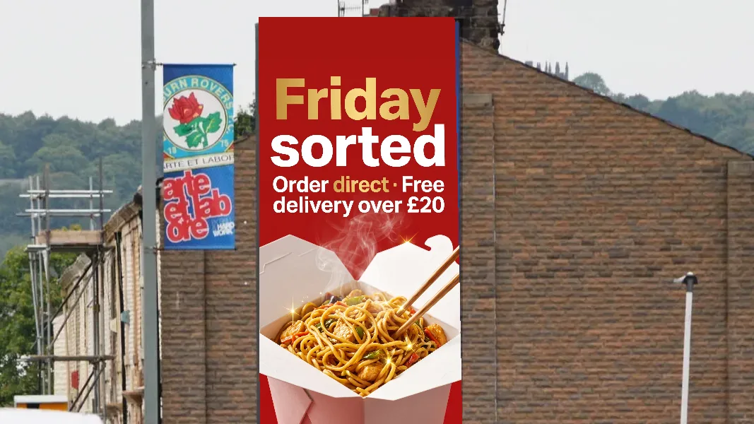 Example noodle takeaway ad reading Friday sorted, order direct, on a tall roadside digital screen near Ewood Park, Blackburn