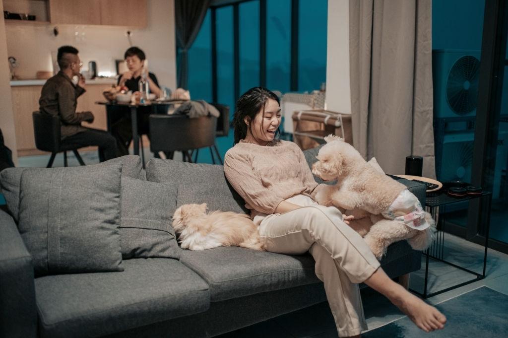 Woman in serviced apartment with dog on couch