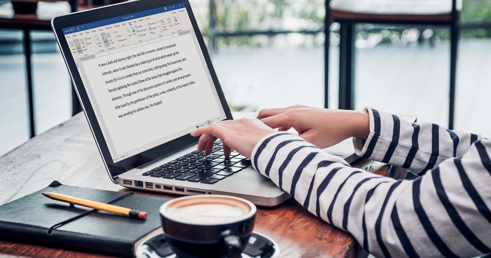 A freelancer writes content for a website on a laptop with a cup of coffee on the table.  She is looking for content writing jobs.  Viết content freelancer, tuyển dụng content writer, content freelancer, công việc viết lách, dịch vụ viết content.