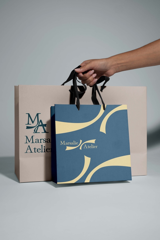Desain logo minimalis dengan warna biru dan kuning, logo untuk brand bernama "Marsalie Atelier"