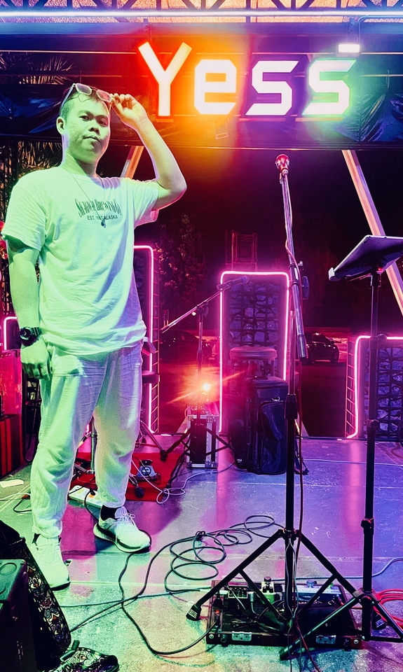 นักดนตรีวงดนตรีไทยกำลังแสดงสดบนเวที มีไฟสีสันสวยงาม