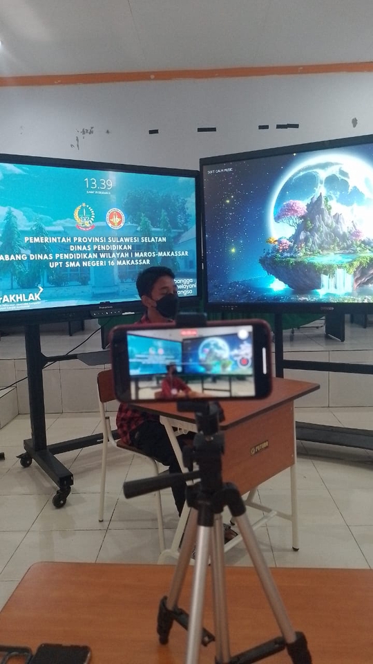 Freelance video editor mengedit video di studio dengan menggunakan tripod