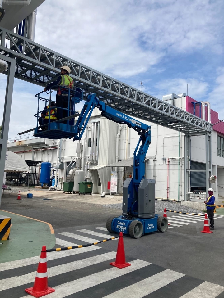 ช่างเทคนิคกำลังใช้รถยกเพื่อซ่อมบำรุงระบบเครือข่ายบนอาคาร