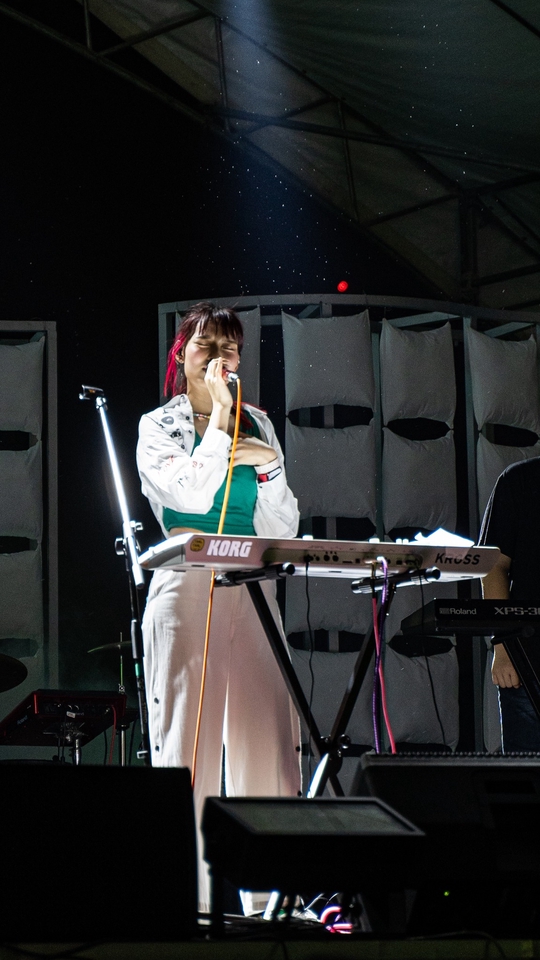 ช่างภาพหญิงร้องเพลงบนเวทีงานดนตรี