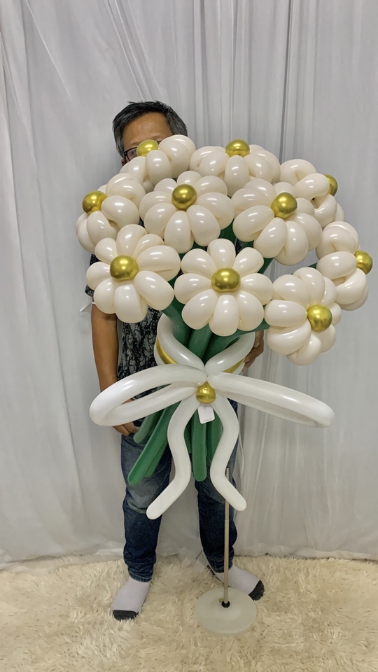ช่อดอกไม้บอลลูนสีขาวตกแต่งด้วยลูกโป่งสีทอง เหมาะสำหรับใช้ในงานวันเกิด งานแต่งงาน หรือโอกาสพิเศษอื่นๆ