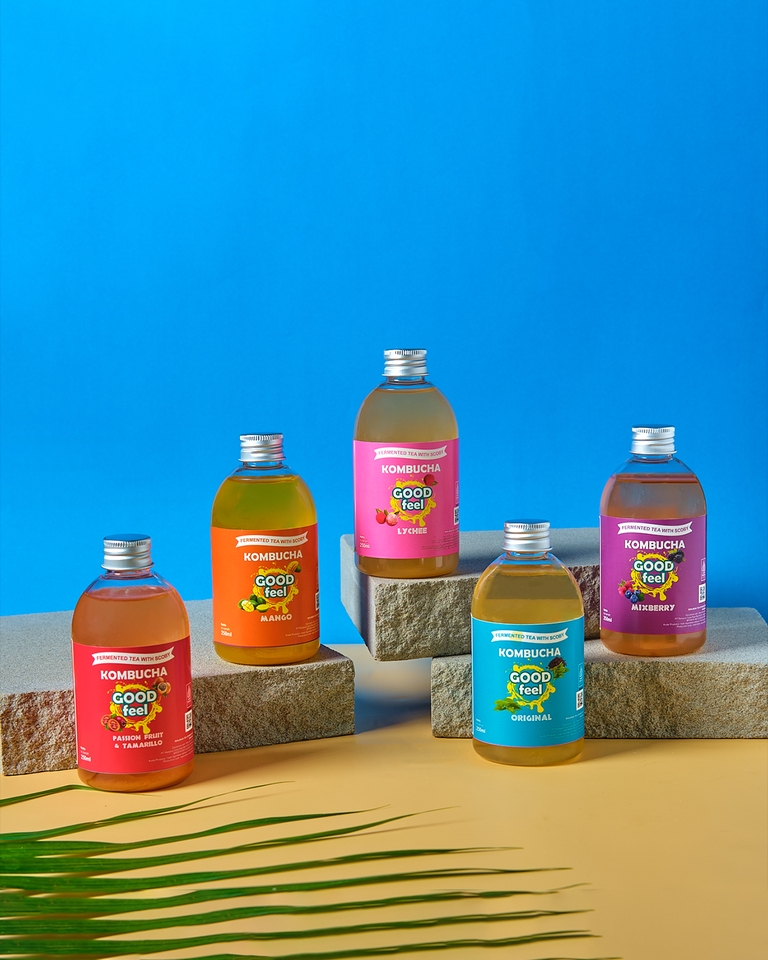 Jasa Foto Produk Kombucha dengan latar belakang biru dan putih untuk bisnis online shop.