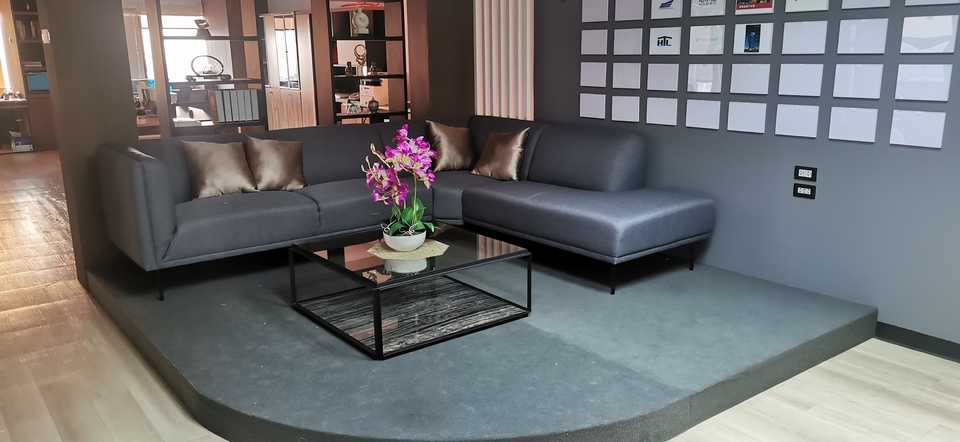 ภาพห้องรับรองพร้อมโซฟาหนังสีเทาเข้ม, โต๊ะกลางกระจก, และดอกไม้ เหมาะสำหรับ รับเป็นที่ปรึกษากฎหมาย