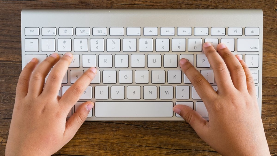 Jasa pengetikan online, seseorang mengetik di keyboard putih untuk layanan pengetikan dokumen.