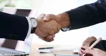 Dua orang bisnis profesional berjabat tangan, menunjukkan layanan konsultasi hukum profesional yang diberikan oleh konsultan hukum.