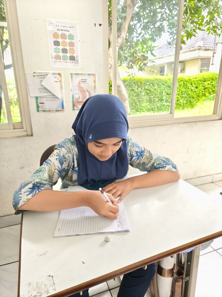 Seorang siswa wanita berhijab belajar online di rumah menggunakan laptop.