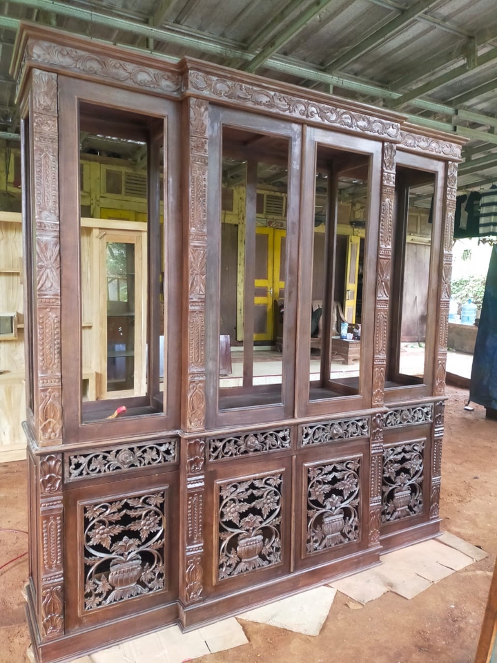 Desain lemari kayu ukiran dengan detail rumit untuk ruangan tamu atau ruang keluarga, furniture minimalis modern