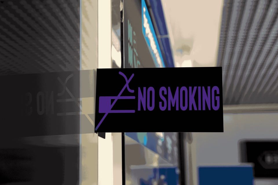 Tanda larangan merokok di dalam ruangan publik, desain grafis sederhana dan minimalis dengan warna dasar hitam dan teks ungu "NO SMOKING".