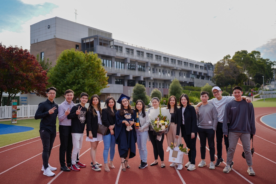 Jasa Fotografi untuk acara wisuda, foto grup mahasiswa, dengan latar belakang kampus dan gedung perkuliahan.