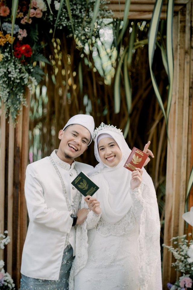Jasa fotografi pernikahan, pasangan pengantin muslim memegang buku nikah