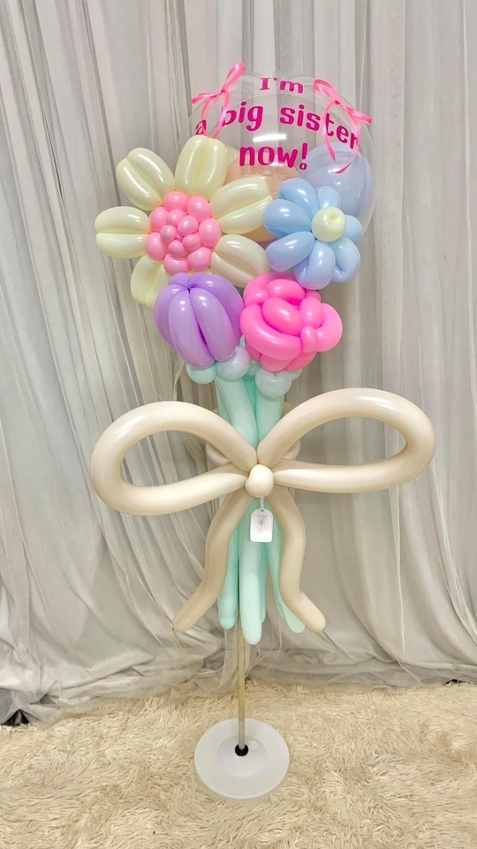 ลูกโป่งดอกไม้สีพาสเทลสำหรับการเฉลิมฉลองการเป็นพี่สาวคนโต พร้อมข้อความ "I'm a big sister now!" เหมาะสำหรับของขวัญวันเกิด รับสอนพิเศษ