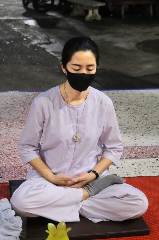 รับจ้างทำบุญ รับจ้างใส่บาตรออนไลน์ ผู้หญิงสวมหน้ากากอนามัยกำลังทำบุญ