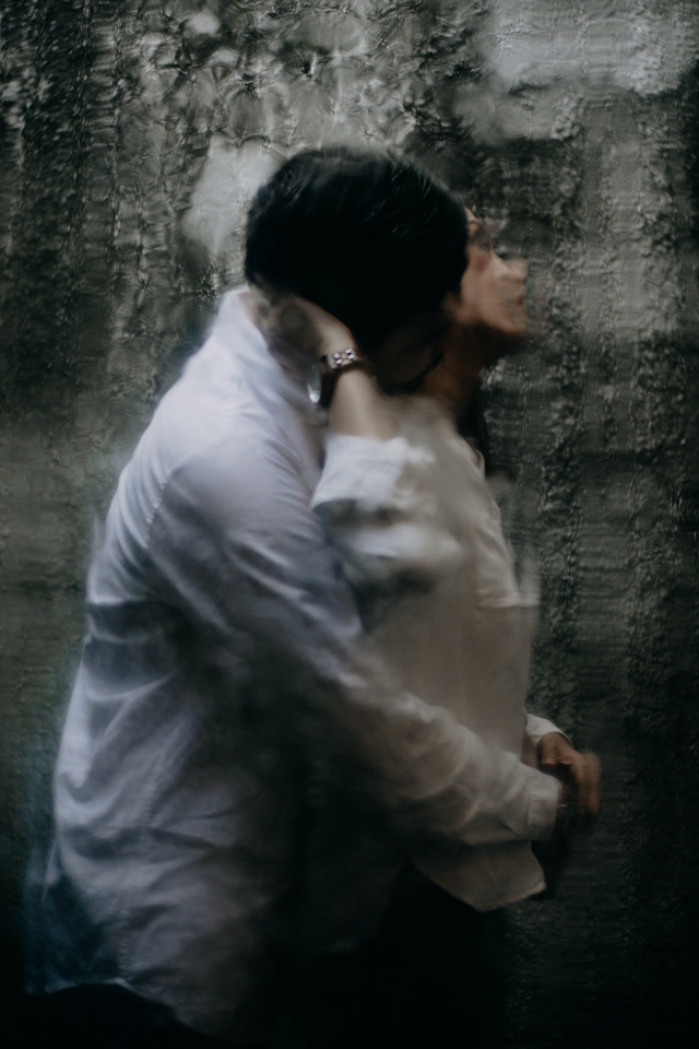 Jasa fotografi pernikahan, pasangan pengantin sedang berpelukan dengan latar belakang tembok