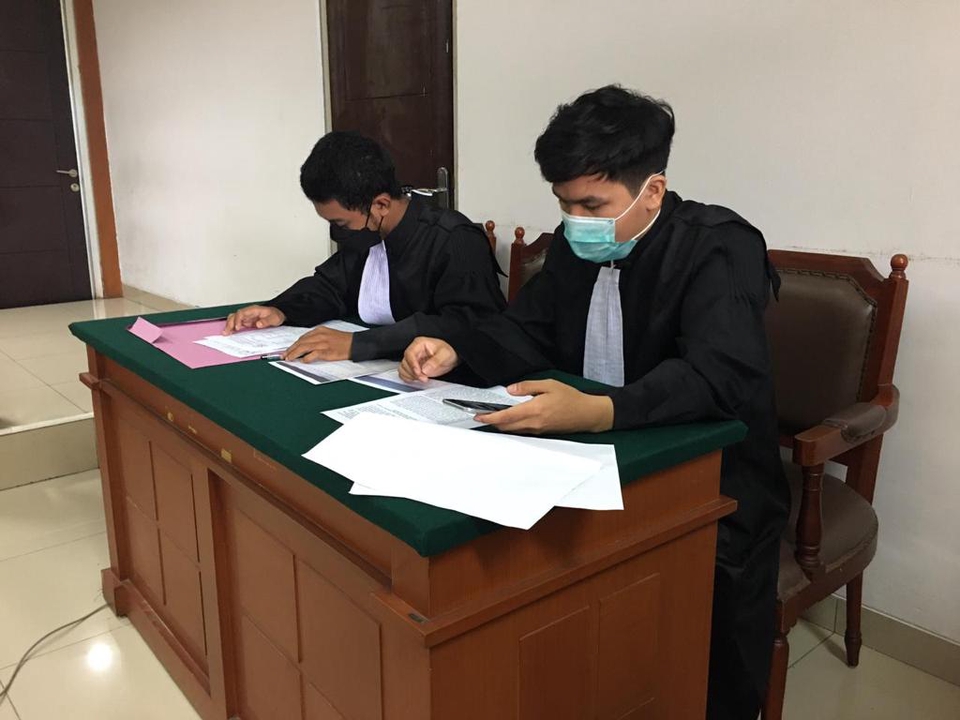 Konsultan hukum dan pengacara sedang berdiskusi di meja kantor hukum tentang kasus hukum