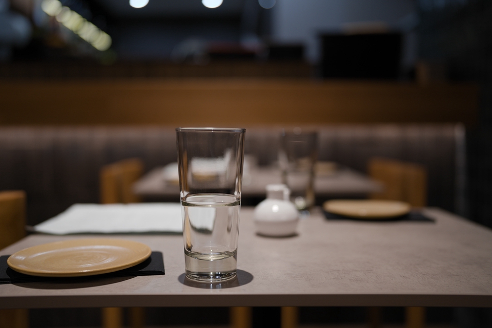 Jasa fotografi produk makanan dengan background putih, makanan di dalam piring dan gelas air di meja.
