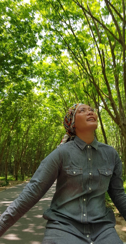 ผู้หญิงกำลังมองดูต้นไม้ที่สวยงามในขณะที่เธอเดินในป่า ซึ่งแสดงถึงการค้นหาความสงบสุขทางใจ
