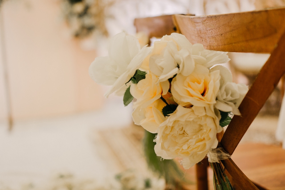 Jasa fotografi wedding dengan dekorasi bunga putih dan kursi kayu