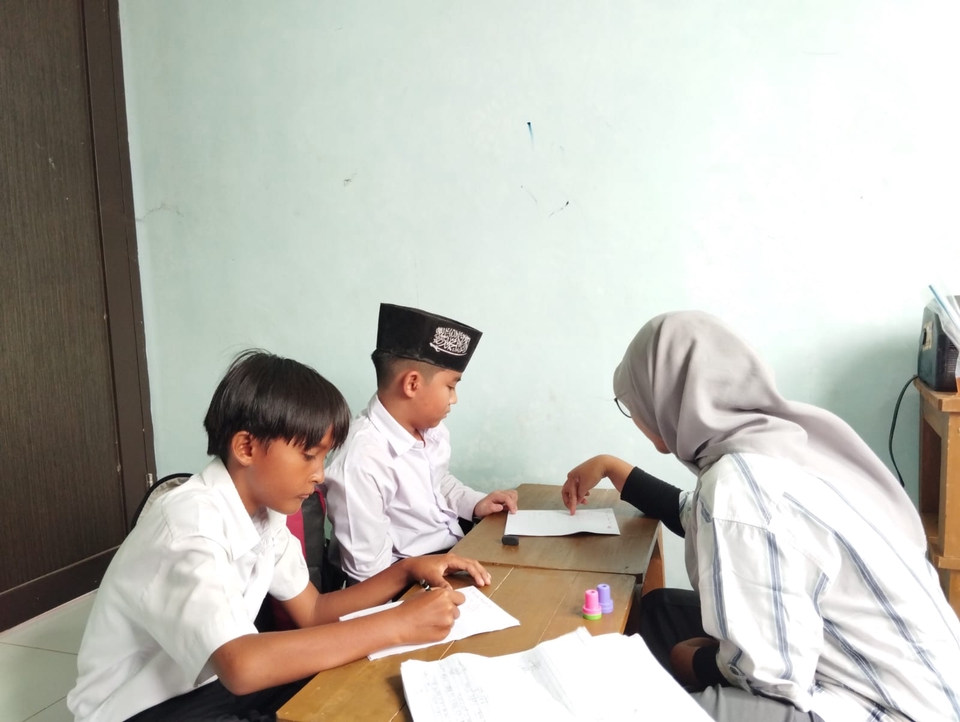 Tiga siswa sedang belajar bersama di kelas les privat.