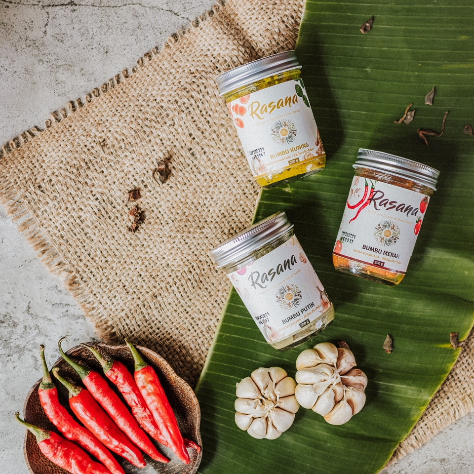 Jasa fotografi produk makanan dengan latar belakang putih, bumbu masakan, cabe merah, bawang putih dan daun pisang.