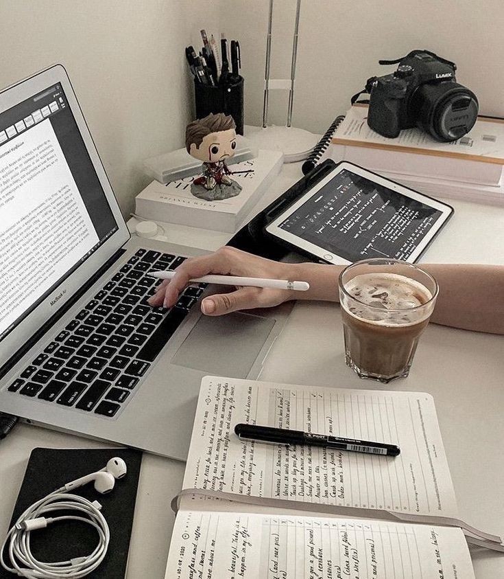 Jasa penulis artikel profesional dengan laptop, buku catatan, dan kopi di meja kerja.