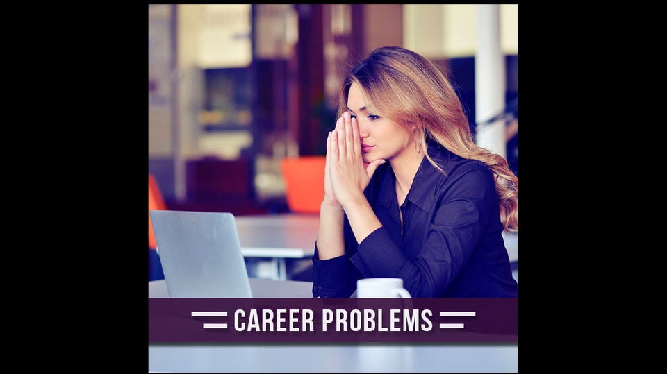 Seorang wanita muda sedang duduk di meja sambil merasa stres tentang masalah karirnya.