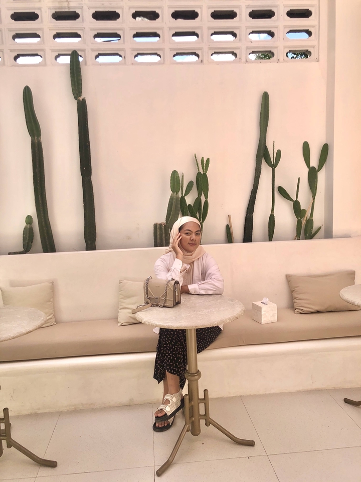 Jasa endorse selebgram murah, selebgram cantik berpose di kafe dengan tas branded.