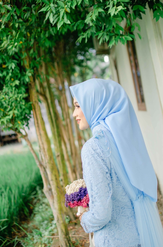 Jasa Fotografi Prewedding dengan gaun biru muda dan buket bunga di tangan wanita