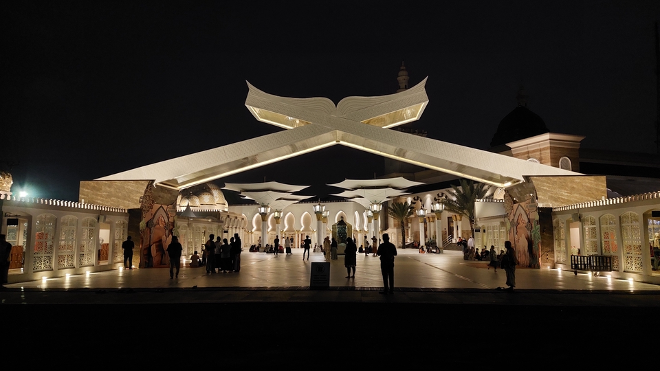 Belajar bahasa Inggris online di kelas virtual dengan suasana masjid di malam hari.