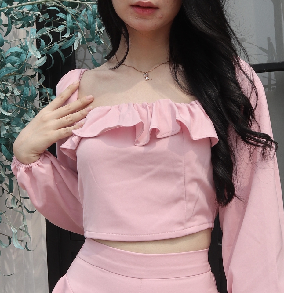 Jasa fotografi wanita berpakaian pink dengan latar belakang hijau.