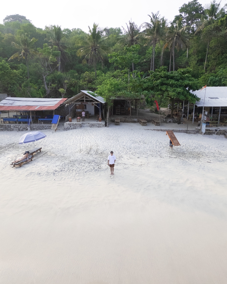 Jasa edit foto prewedding dengan background pantai dan pondok kayu di tepi pantai.
