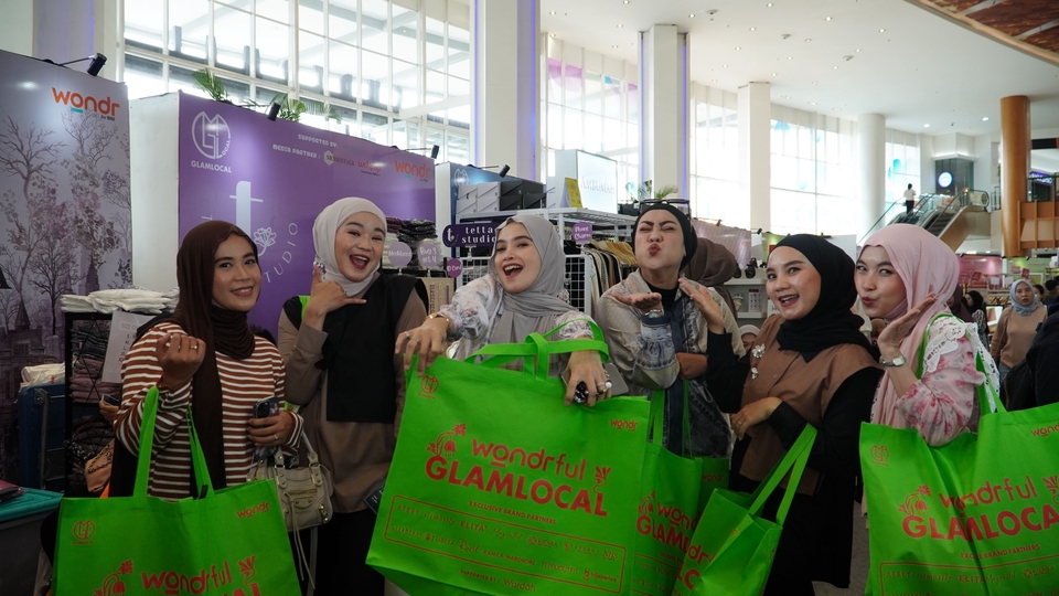 Jasa fotografi untuk keperluan marketing, dengan lima fotografer freelance profesional yang sedang memegang kamera dan tas berisi peralatan fotografi di mall.