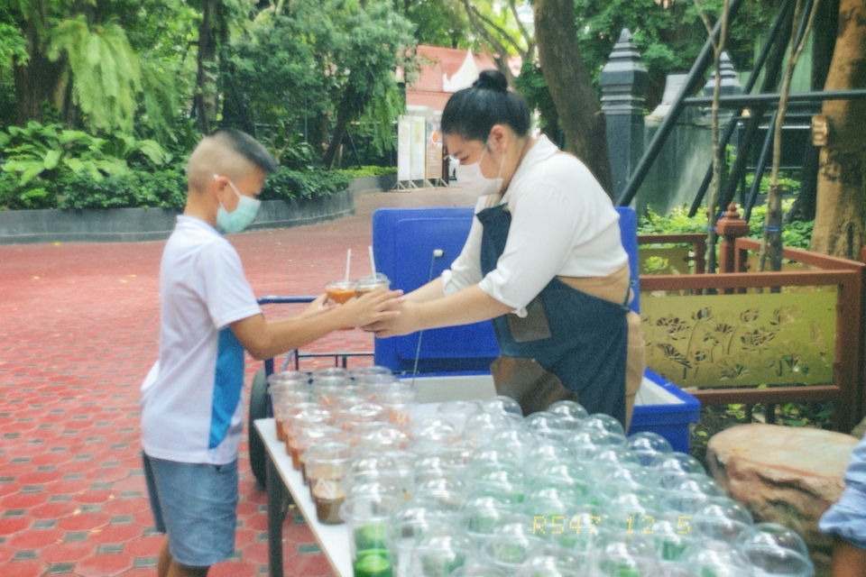 รับจ้างทำบุญ ใส่บาตร ทำบุญออนไลน์ เด็กชายกำลังทำบุญใส่บาตร โดยมีหญิงสาวคอยช่วย