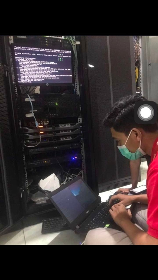 Teknisi komputer freelance memberikan jasa IT support dan konsultan IT kepada kliennya di ruang server.