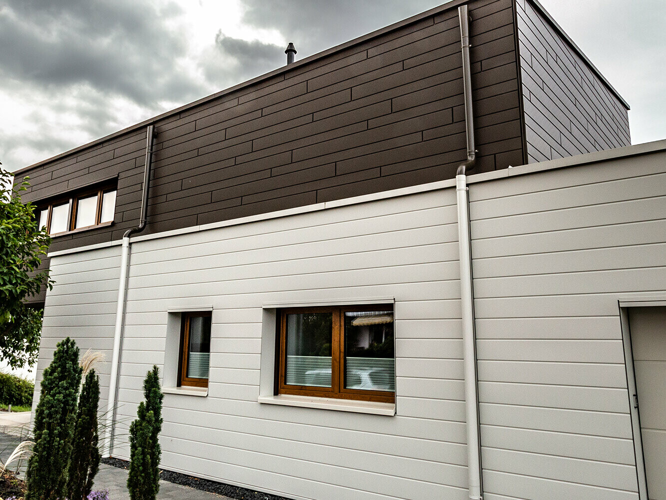 csm_PREFA-Sidings-horizontal-prefa-weiss-braun-unregelmaessig-verlegt-Fallrohr-Ablaufrohr-Aluwandfassade_b1cfb2660f