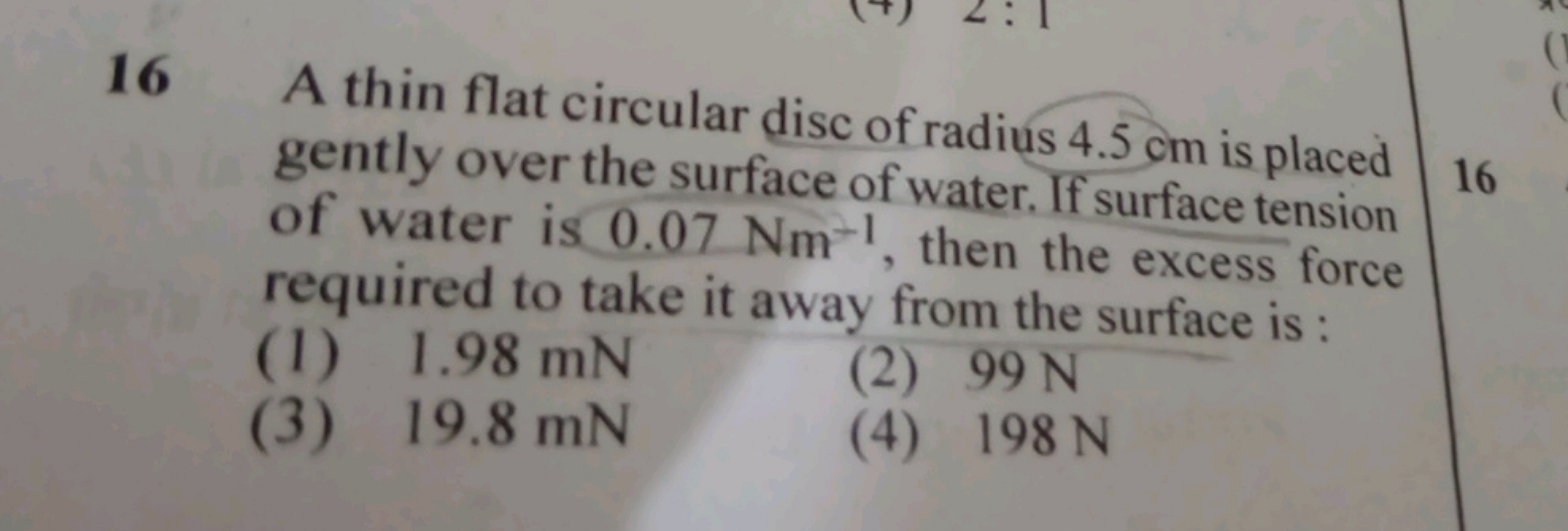 16 A thin flat circular disc of radius 4.5 cm is placed gently over th