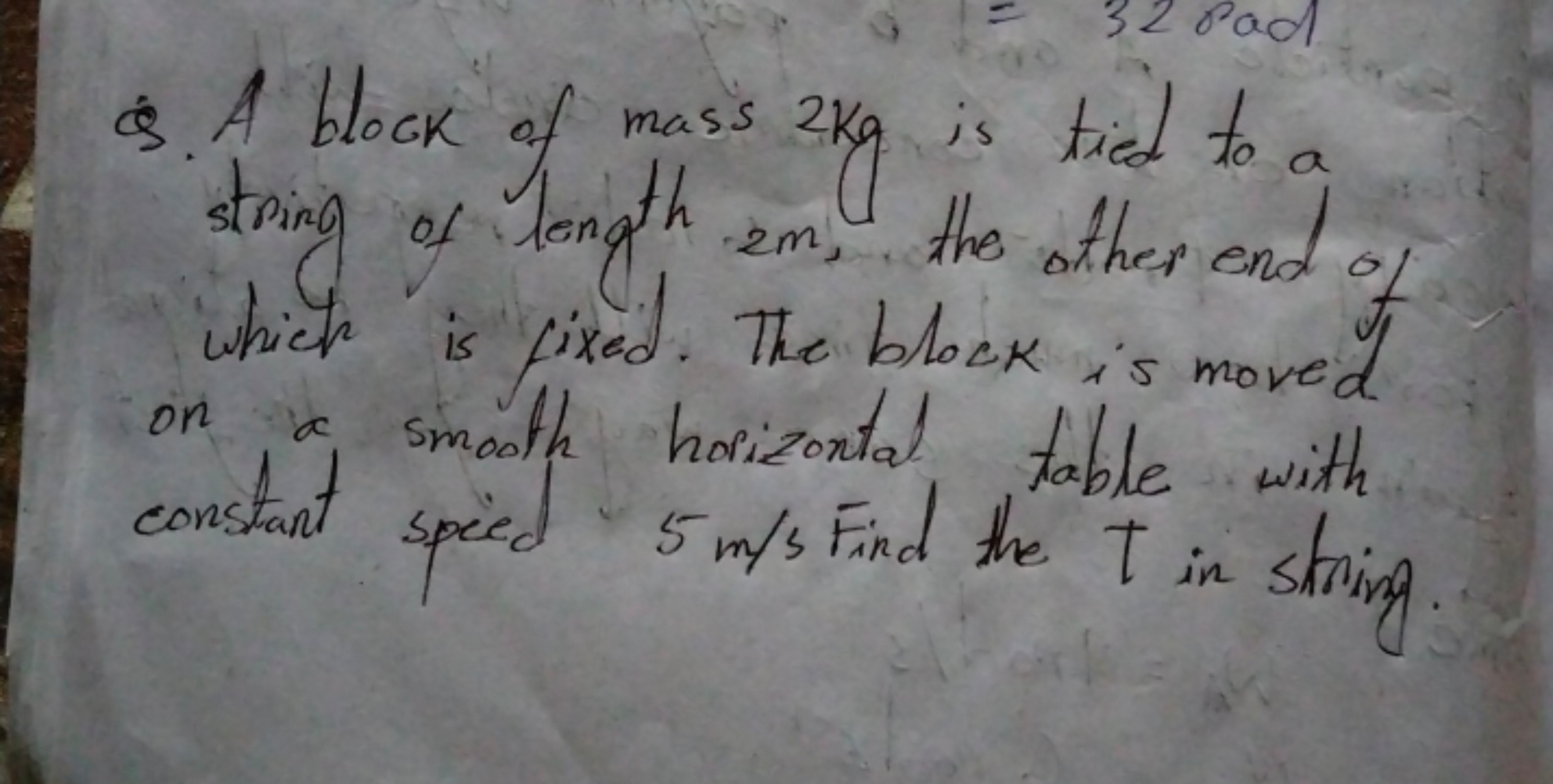 Q. A block of mass 2 kg is tied to a string of length 2m, the other en